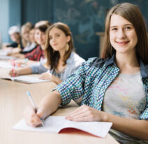 happy-girl-with-classmates-table